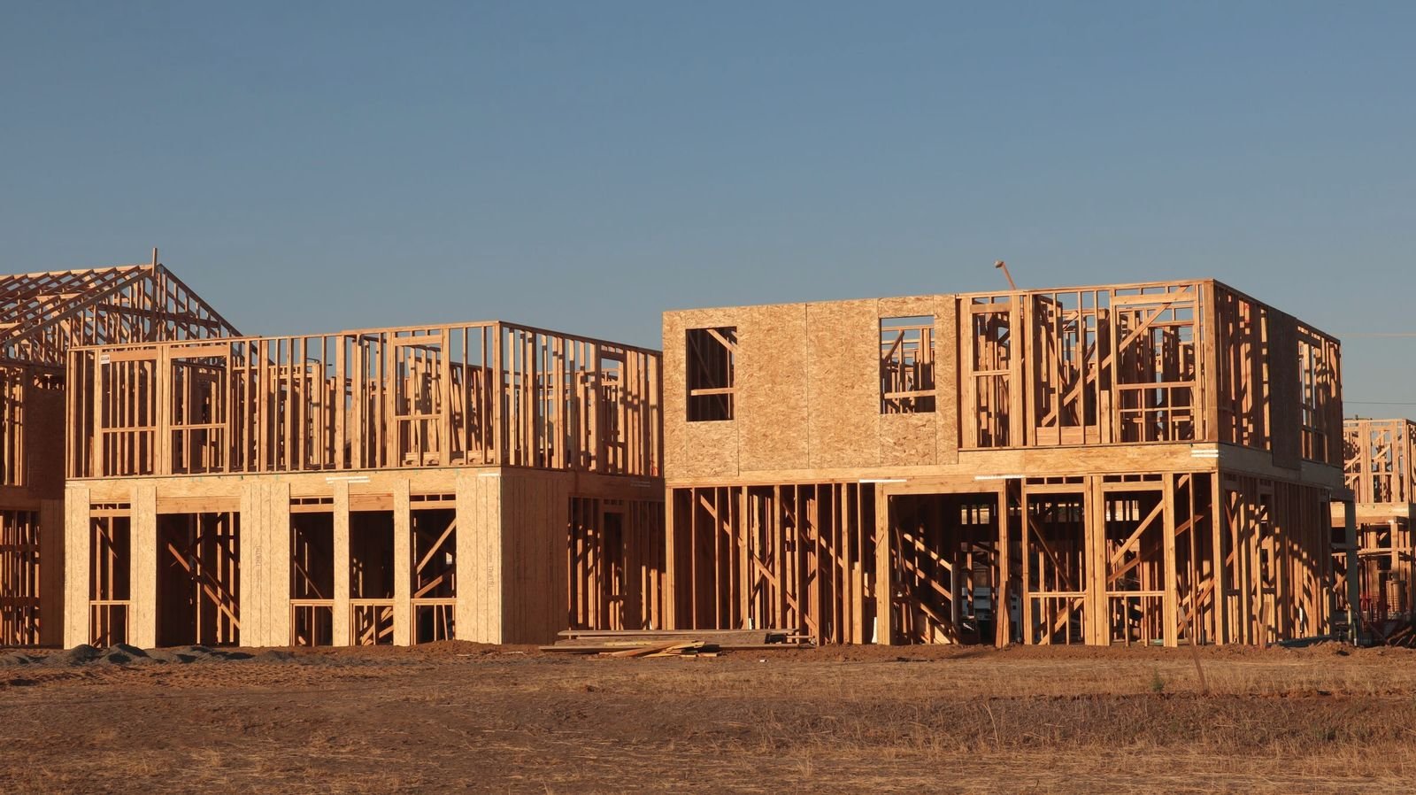 New houses framed up on prepared lots at sunset