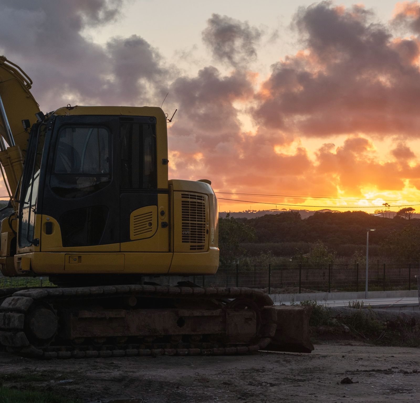 Excavator parked at the end of the day with the sun going down