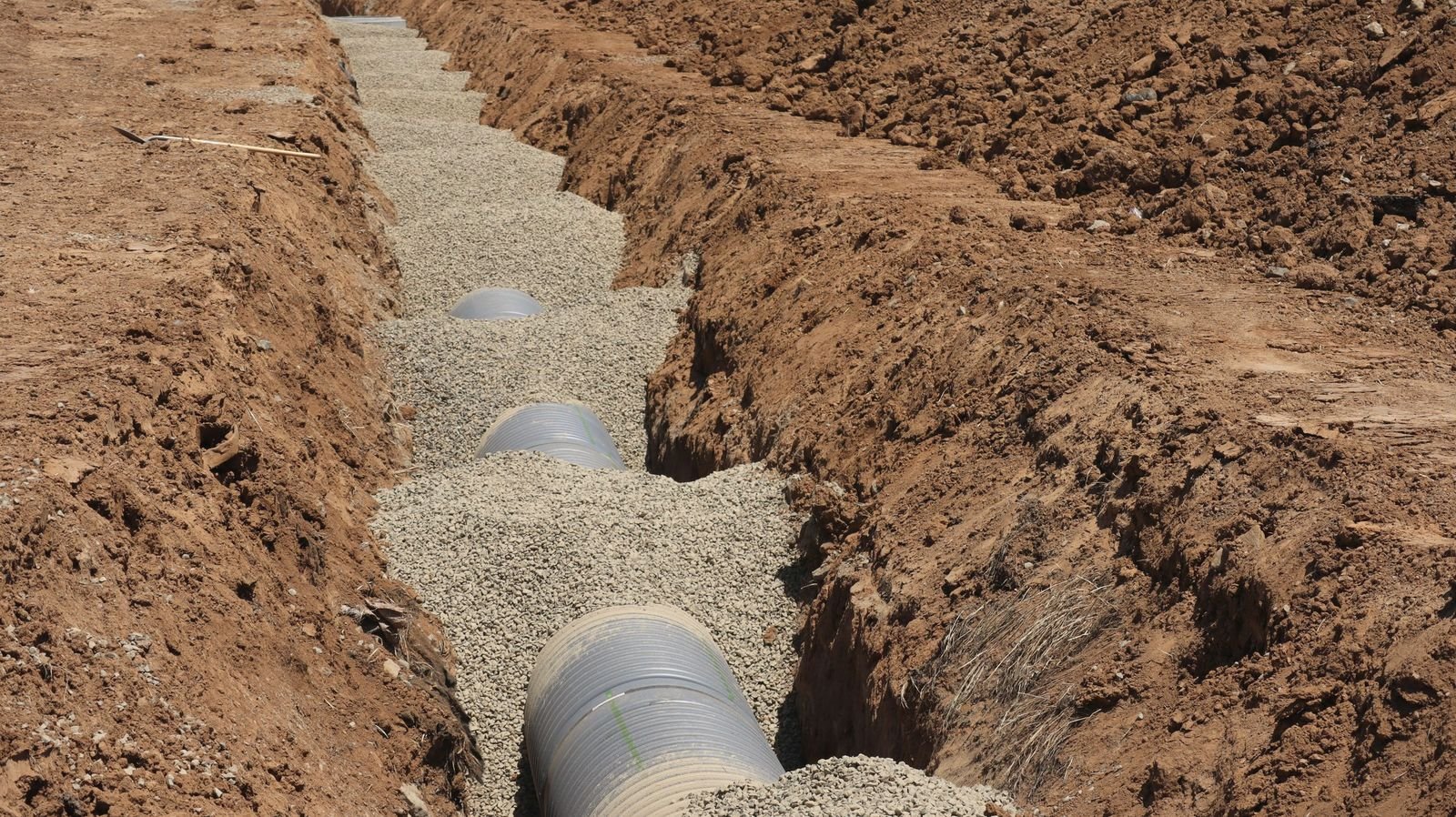 Drain line laid on gravel bedding in an open trench